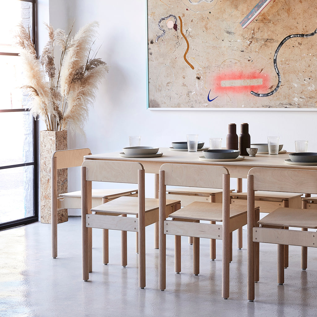 Dining Room with Minimalist Natural Coloured Wooden Dining Table and Chairs with Tablewares on Top