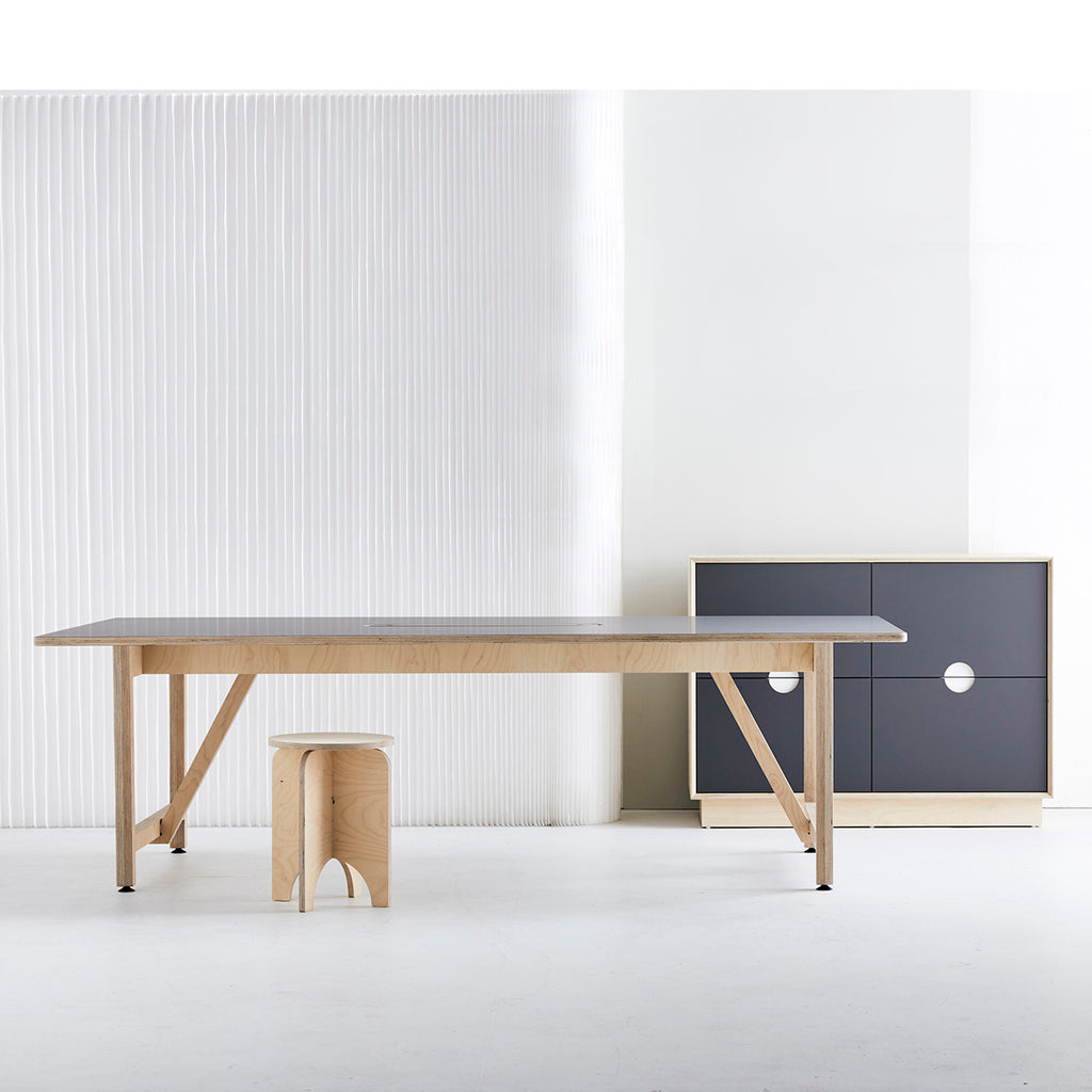 Long Work Table, Wooden Stool and Black Cabinet in a White Painted Room