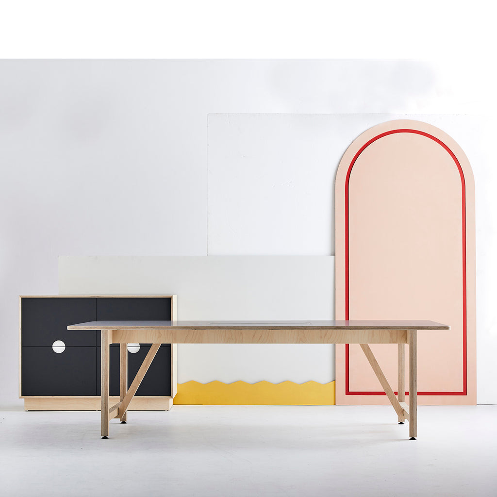 Long Work Table with Wooden Base and Black Coloured Cabinet Behind