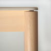Wooden table leg and top on a light gray background
