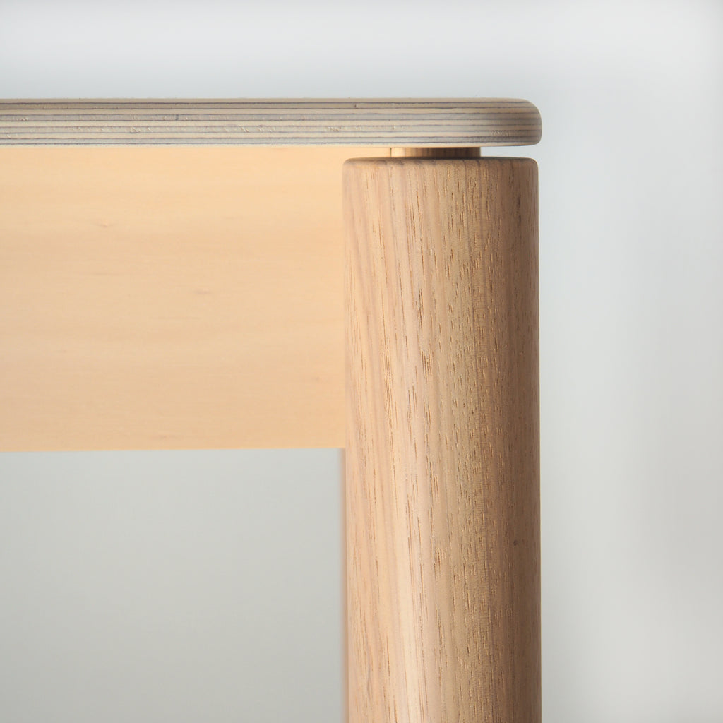 Wooden table leg and top on a light gray background