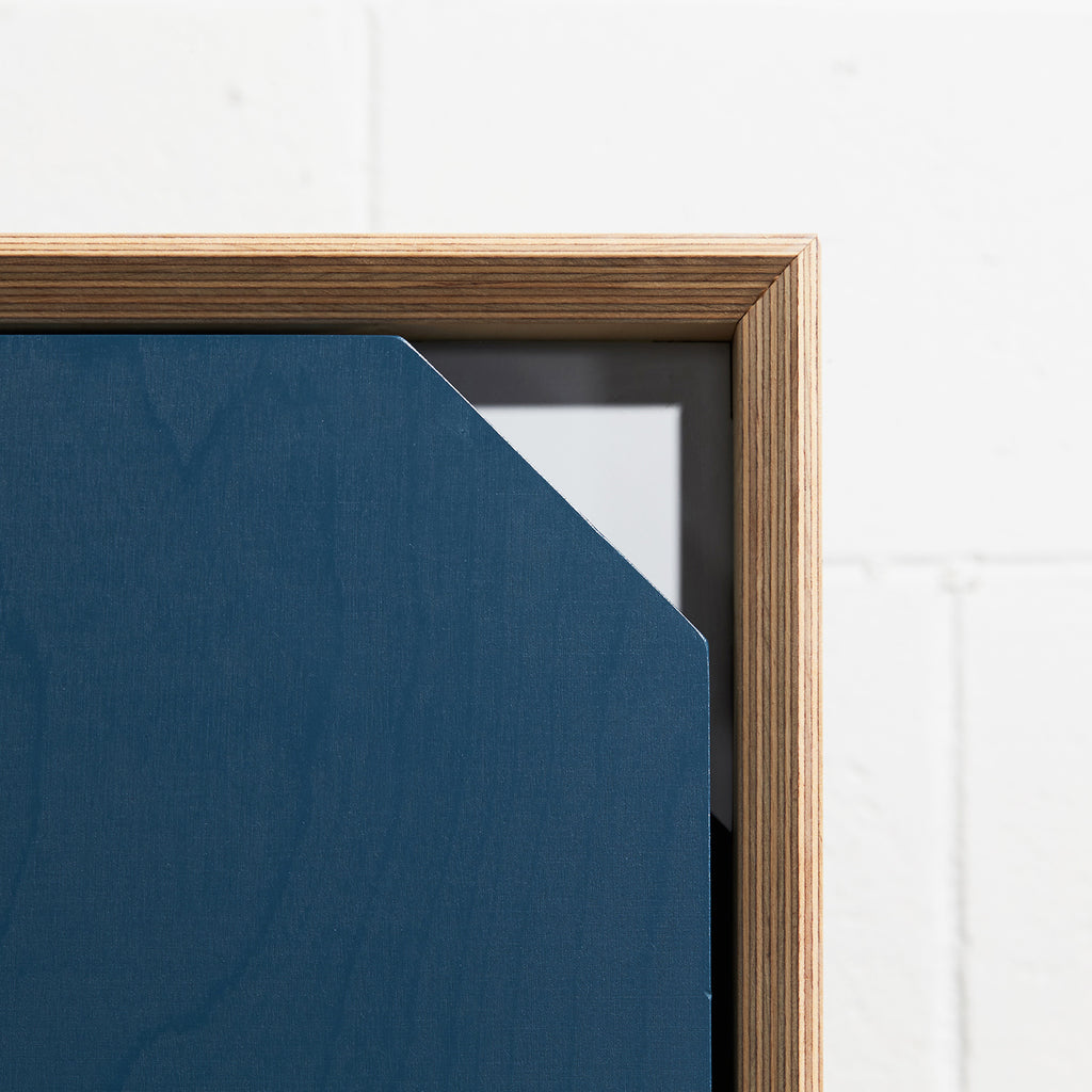 Cut-out Edge Detail View of Plywood Fold Out Storage Desk in Navy Blue