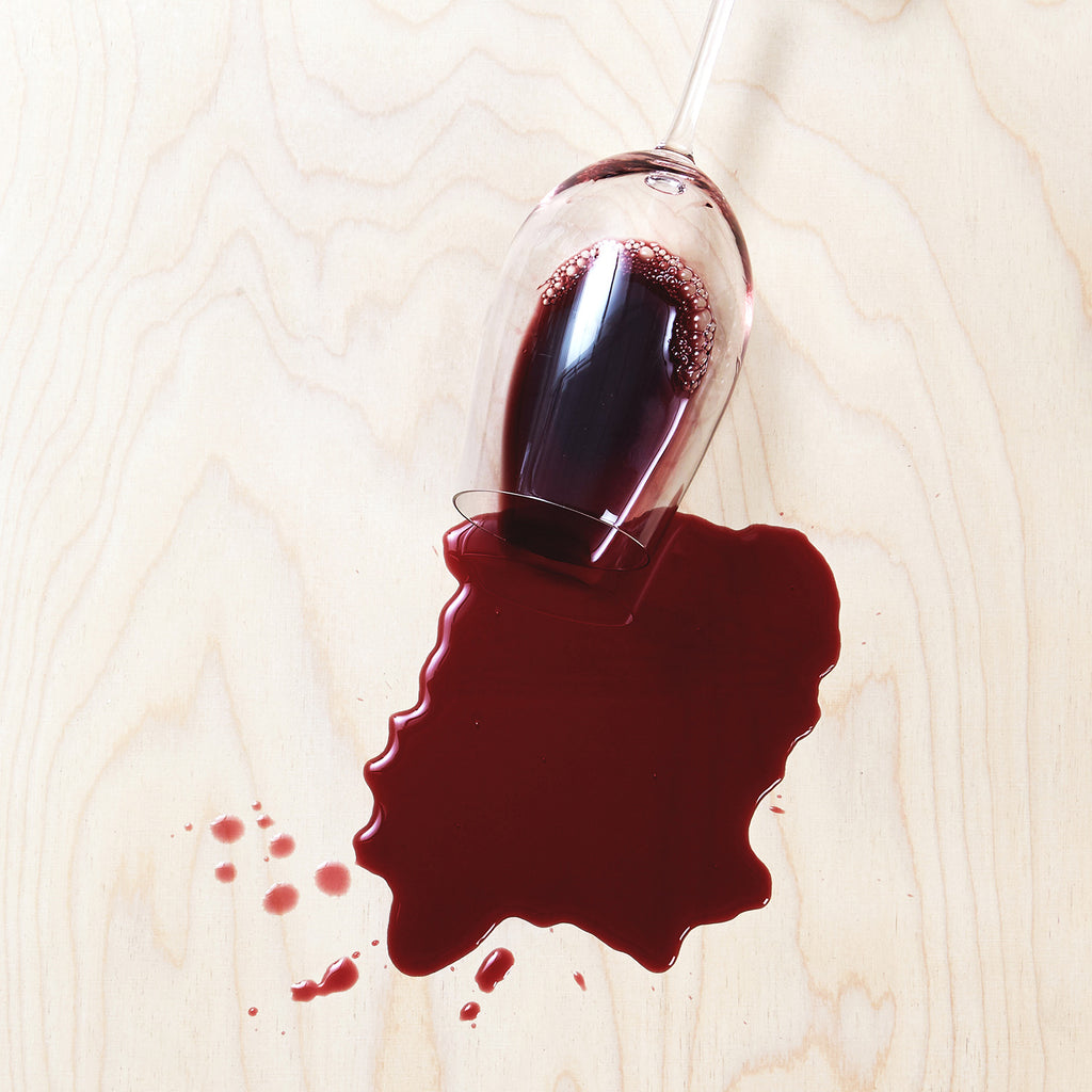 Spilled Red Wine from Overturned Glass on a Wooden Surface