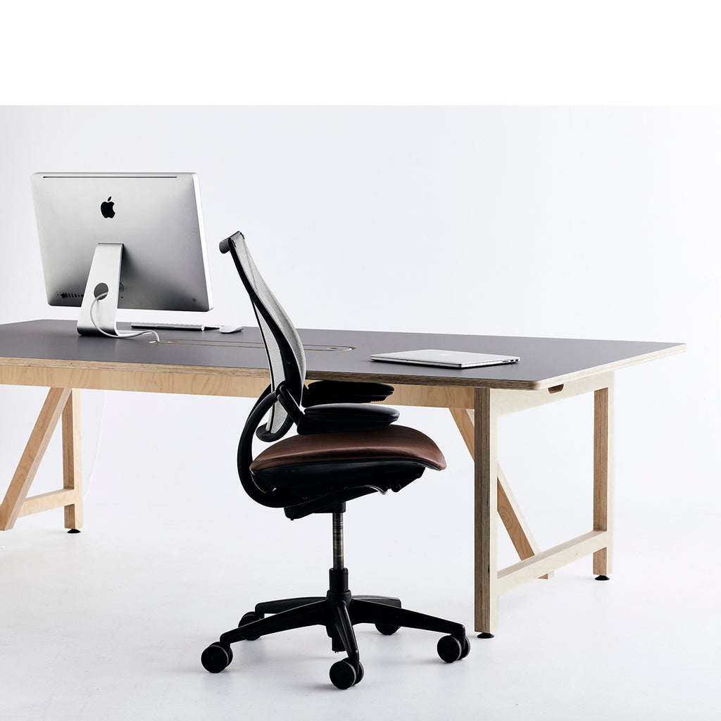 Long Work Table with iMac on Top and a Brown Swivel Office Chair